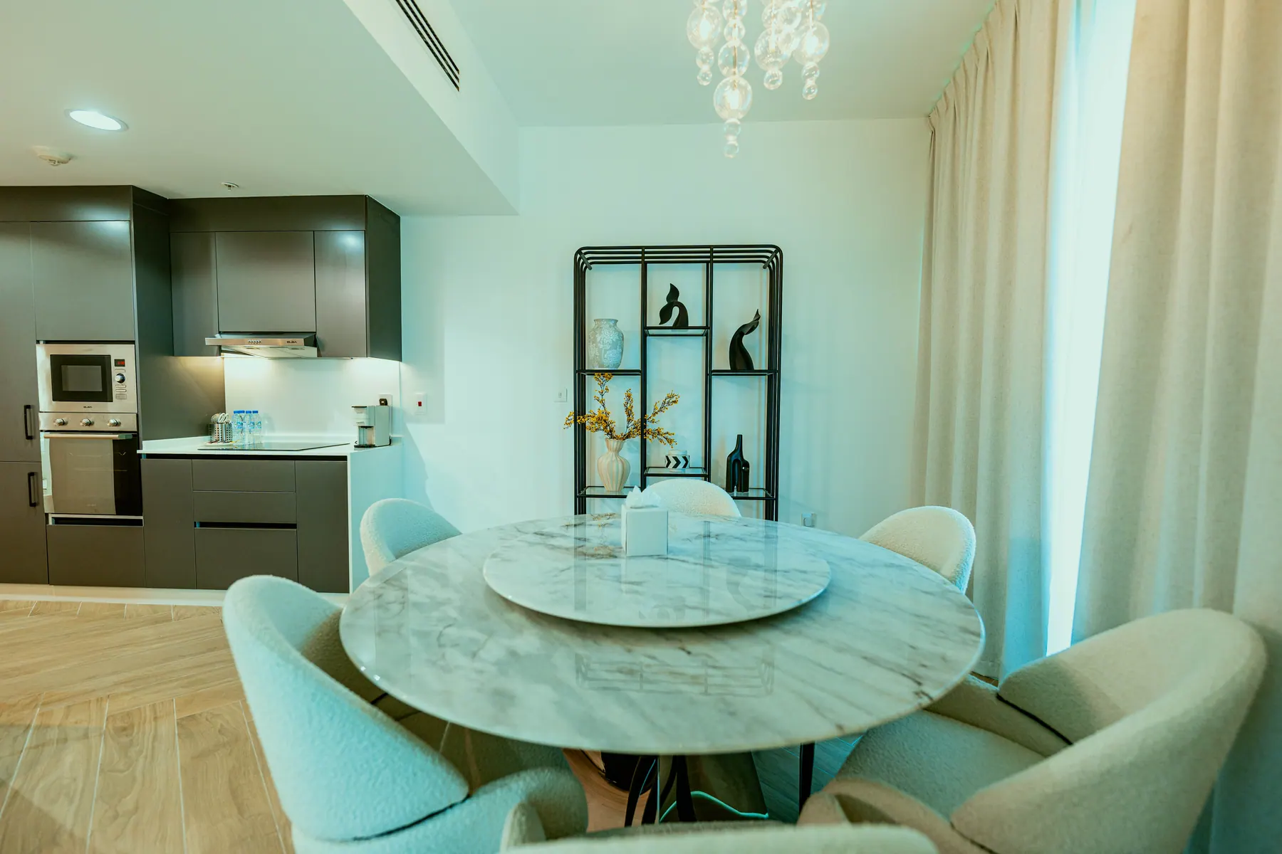 Dining area with a marble table and boucle chairs in Dubai Marina
