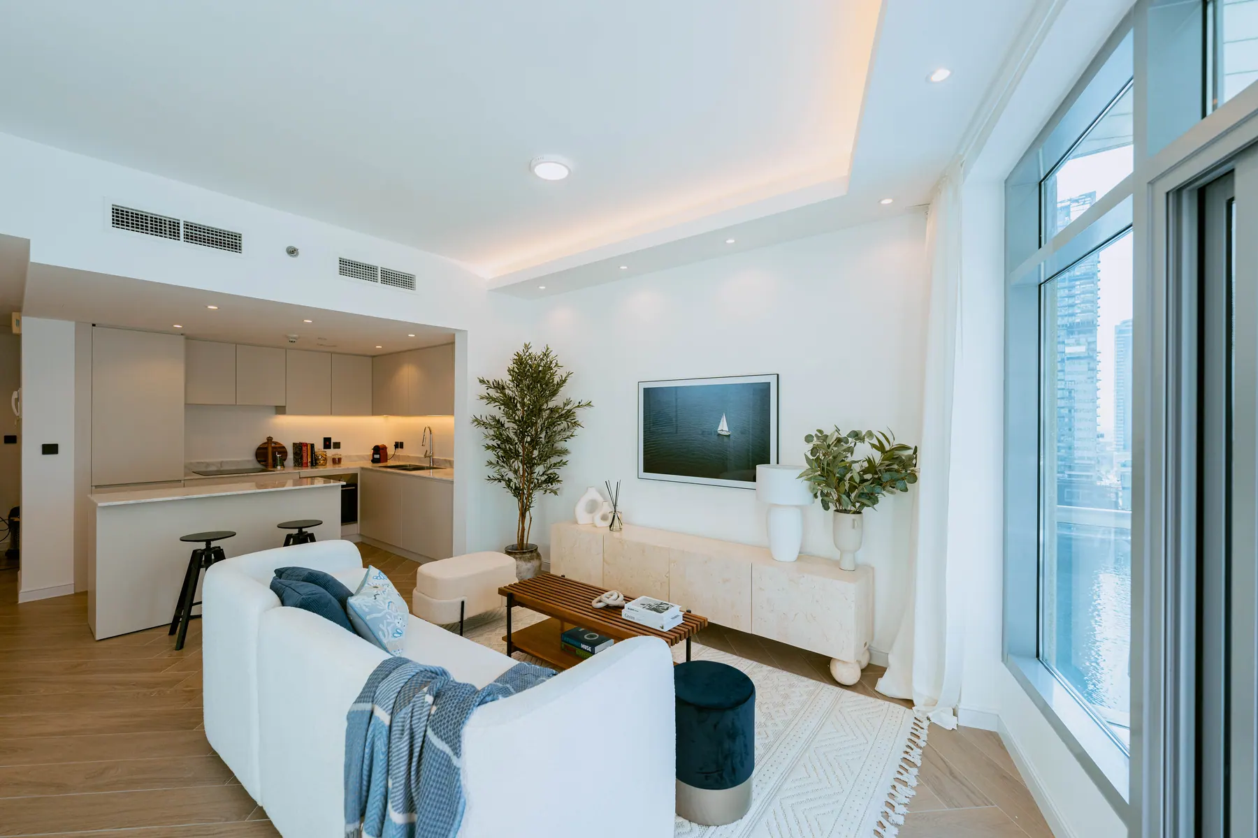 Park Island apartment living area with a curved sofa and full-height glazing